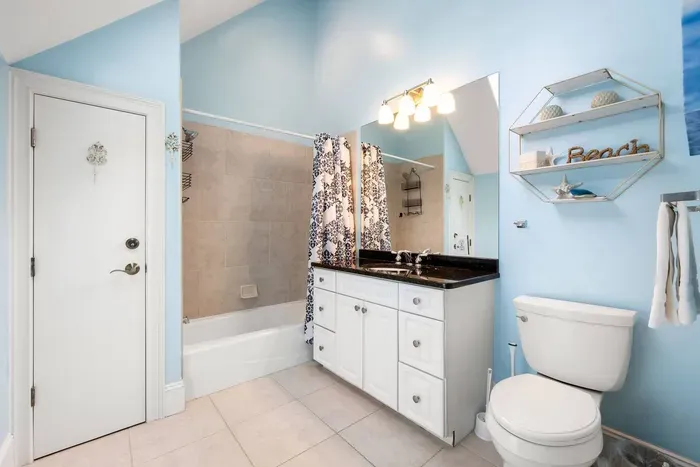 Upstairs bath with a tub-shower combo and a granite vanity.