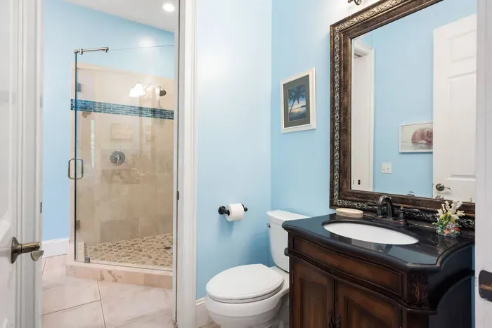 Guest bath with a glass walk-in shower and a furniture-style vanity.