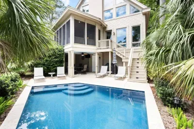 The whole back of the house: pool, covered patio, screened porch, and that window wall above.
