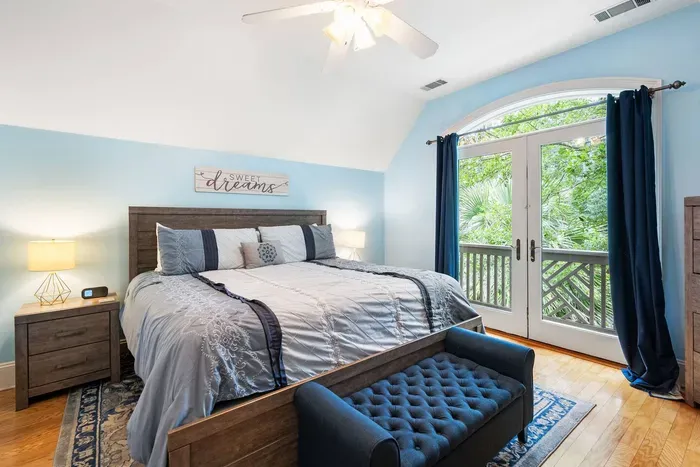 Upstairs king suite under a vaulted ceiling with French doors to a private balcony. The quiet corner of the house.