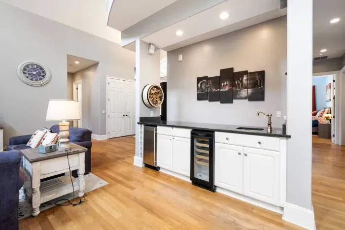 The wet bar: granite top, prep sink, wine fridge, and a separate beverage fridge. Stocked and ready before anyone unpacks.