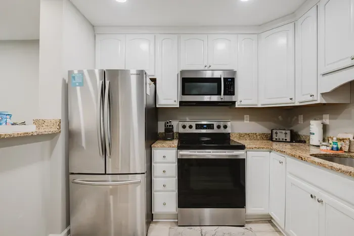 Samsung fridge, full-size range, microwave, dishwasher, and a knife block — set up to cook real meals, not just reheat.