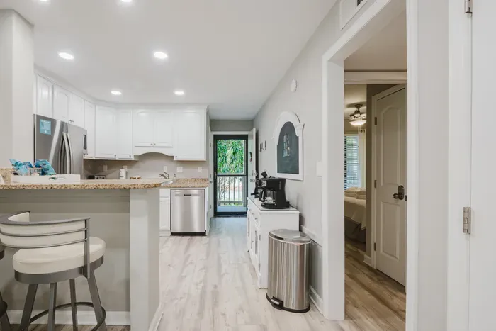 View from the living room to the private entrance. Coffee bar along the hall, kitchen to the left, and the door out to the landing. Everything within a few steps.