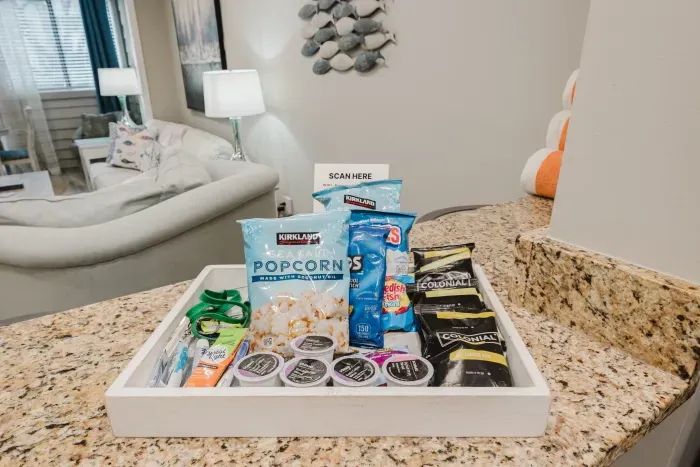 A welcome tray waiting on the counter: popcorn, snacks, and starter coffee pods. One less stop on arrival day.