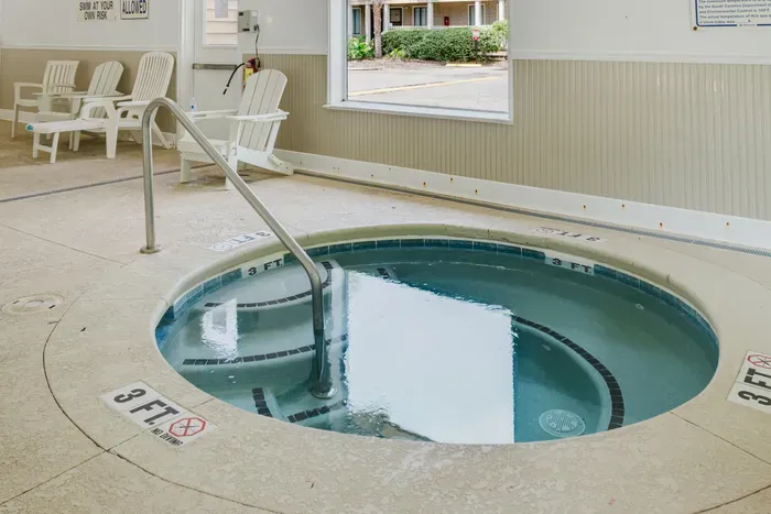 Bright indoor hot tub with seating for year round relaxation.  This is inside the shared community indoor pool facility.