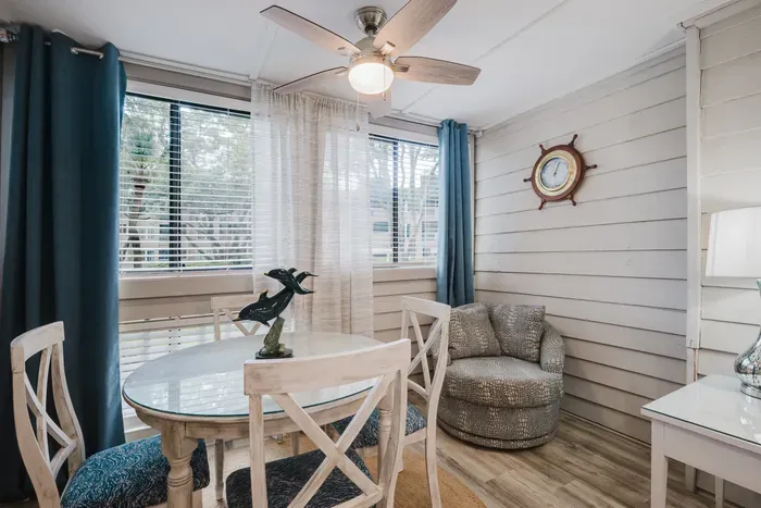 Bright coastal dining nook with sunny windows and charming nautical style