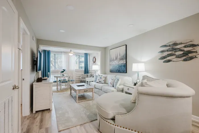 Coastal-styled living room with a sleeper sofa, oversized swivel chair, and smart TV. Room to spread out after a day at the beach.