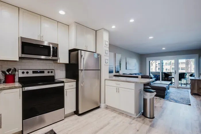 Bright open kitchen with stainless appliances and balcony access