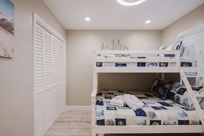 Coastal bunk room with closet storage—perfect for kids or extra guests