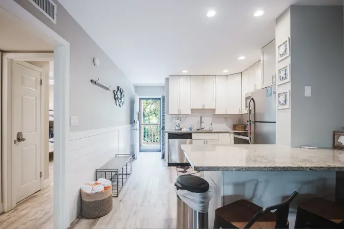 Bright modern kitchen with granite bar, stainless appliances, and airy layout