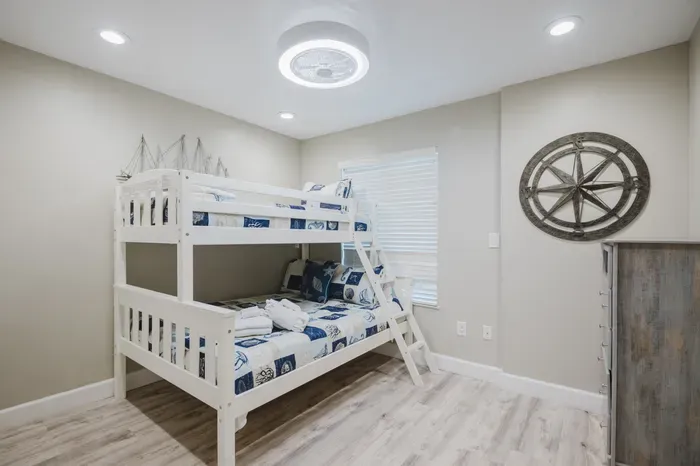 Coastal-style bunk room with bright finishes and space for extra guests