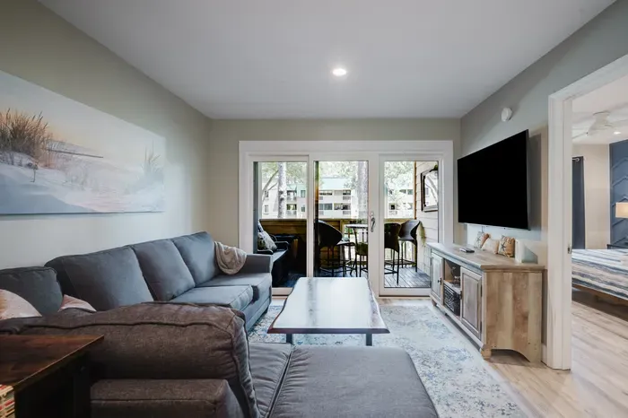 Cozy living room with sectional, TV, and screened porch access