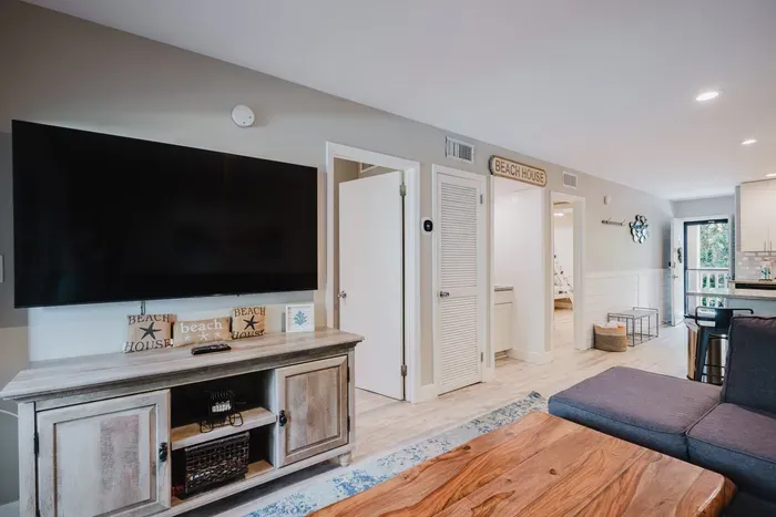 Bright beachy living room with large TV and open-concept layout