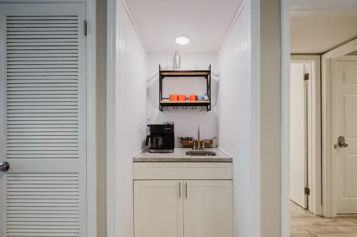 Convenient coffee nook with sink, storage, and guest-ready drink essentials