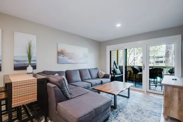 Bright, cozy living room with sectional and private balcony seating