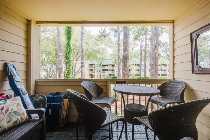Covered balcony with bistro seating and serene wooded views