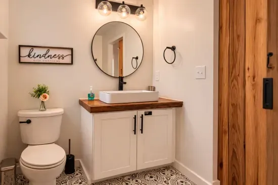 The vanity and toilet area in the Master standard-king bathroom are located opposite the barn door. This spacious bathroom also features a vintage shower and plenty of room to get ready comfortably.
