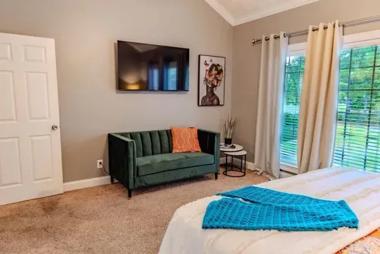 This serene master suite features a vaulted ceiling and tufted king bed. Three tall windows with soft drapes let in natural light with waterfront view. 

All beds and pillows in house have mattress protectors and pillow protectors. 