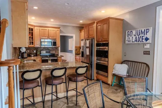 A modern, open-concept has three ovens stylish pendant lights create an inviting space perfect for cooking and gathering.

A second refrigerator is available in the game room area by the bar next to this room. It allows for easy entertainment.