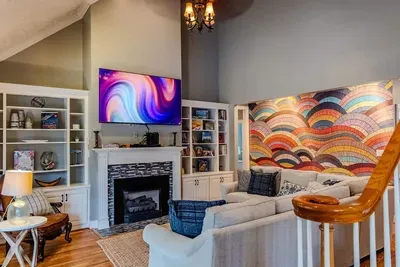 Living room has a vaulted ceiling. Master bedroom and another guest room are on bottom floor. To left of living room is the patio and pool area.