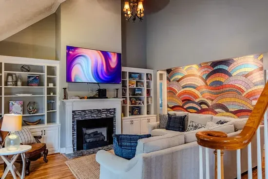 Living room has a vaulted ceiling. Master bedroom and another guest room are on bottom floor. To left of living room is the patio and pool area. 