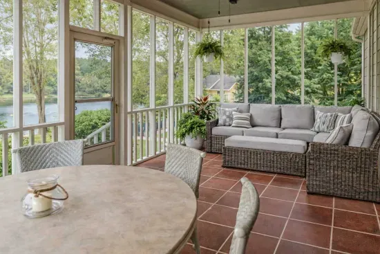 A cozy back porch invites relaxation and overlooks the pool, a tranquil lake and fish pond— offering peaceful views and the soothing sounds of nature.