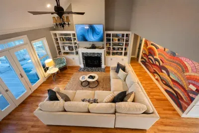 Vaulted ceilings, hardwood floors with a large sectional sofa, 75" UHD Smart Tv, fireplace, small book collection, board game collection, and a pull out queen sofa!!  Patio doors lead to pool!