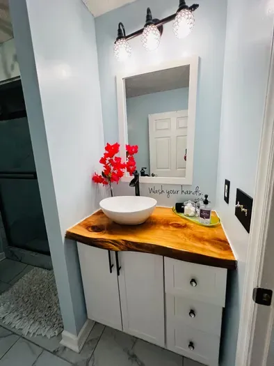 Bathroom vanity area has a custom, handmade slab by Daniel's Sawmill.