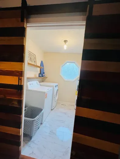 New washer and renovated laundry area in May 2025. Custom shelves and calico barn doors by Daniel’s Sawmill.