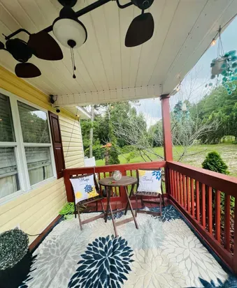 Front patio area. Outdoor seating with lights and grill is in background. 