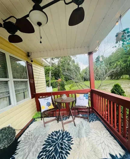 Front patio area. Outdoor seating with lights and grill is in background.
