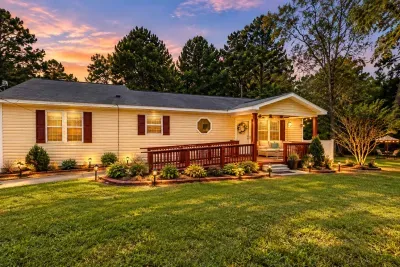 Farmhouse view from the front yard. There is a wheelchair ramp and wider doors but the house doesn’t meet all ADA requirements. 

Front yard has sand mixed with grass due to being in the Sandhills of NC.