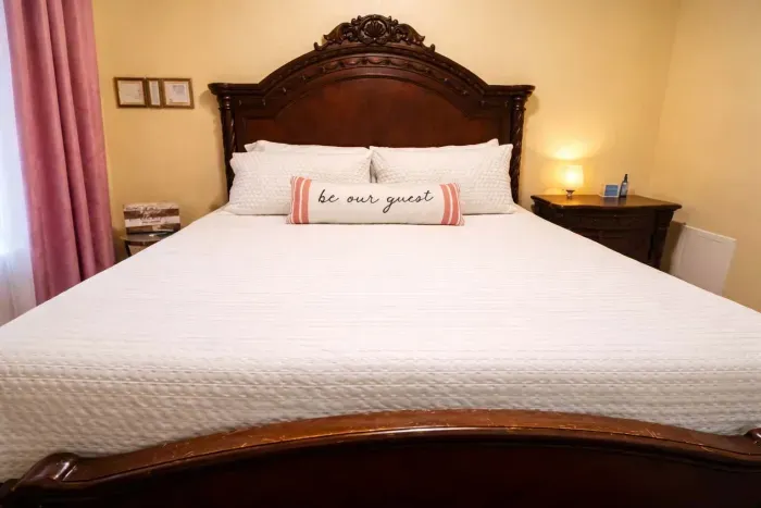 The primary king bedroom is located downstairs and features a 55-inch TV.  Attached is a private en-suite bath. The toilet is thoughtfully separated from the main bathroom area, offering added comfort and privacy.