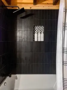 Spacious bathroom with tub shower combo, backlit mirrors and a bluetooth ceiling speaker to listen to music while you bath or get dressed.  