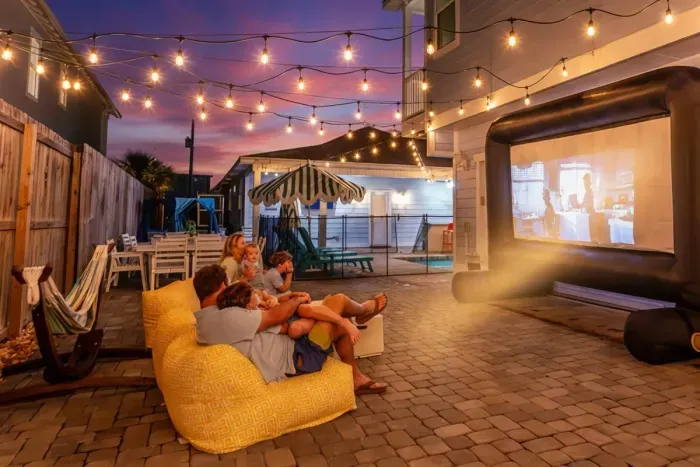 Unwind under the stars with your own outdoor movie theater complete with cozy seating, string lights, and a resort-style atmosphere.