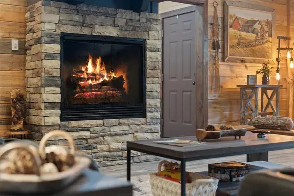 Cozy Stone Fireplace in Rustic Cabin-Style Living Area, Perfect for Relaxing Evenings