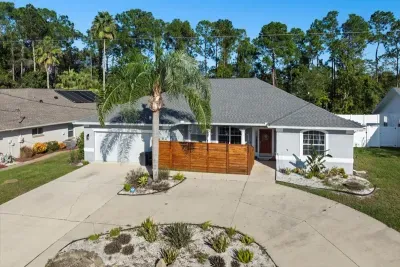 Aerial style view of the front of the home showing the driveway, landscaping, and quiet residential setting.