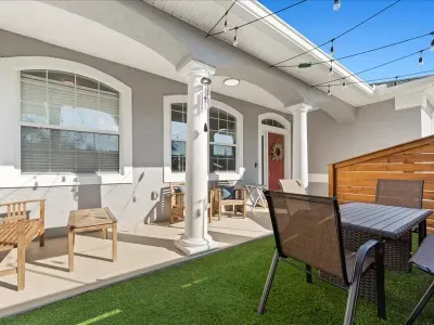 Private patio area with outdoor seating and turf space, ideal for morning coffee or evening relaxation.
