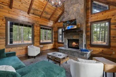Inviting living space with a stunning stone fireplace and natural light streaming through large windows.