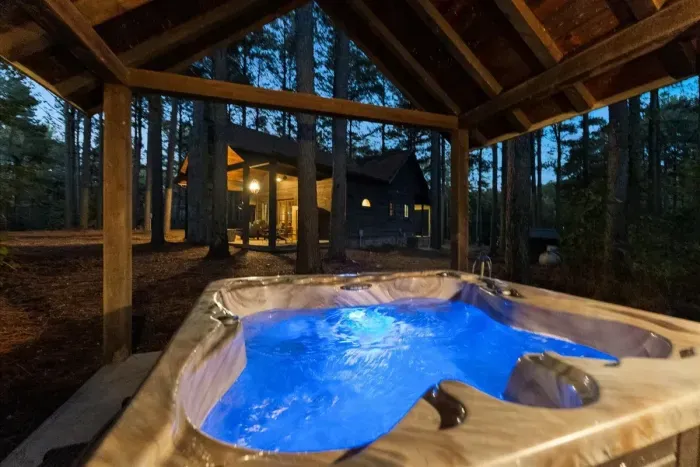 Relax under the stars in your private hot tub surrounded by peaceful pine trees for a quiet mountain escape.