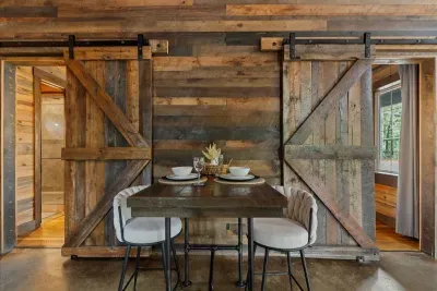 Rustic dining area with wooden barn-style shutters and a warm, intimate atmosphere.