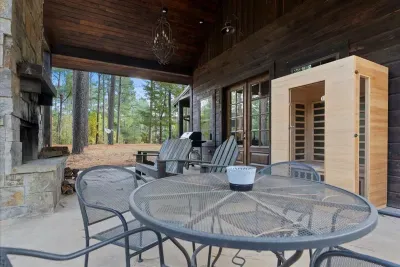 Outdoor lounge area with cozy seating by the fireplace, ideal for evening conversations.