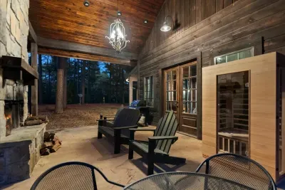 Outdoor lounge area with a fireplace and seating, ideal for unwinding under the trees.