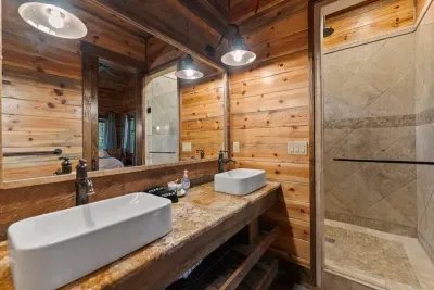Beautiful bathroom with a stone shower, elegant vanity, and warm wood tones.