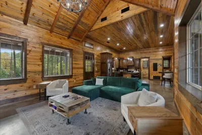 Spacious open-concept living room with vaulted wood ceilings and comfortable seating throughout.