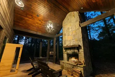 Covered outdoor fireplace area offering the perfect spot to unwind and enjoy the forest view.