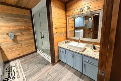 Another clean and modern bathroom with plenty of space, warm wood accents, and everything you need for your stay