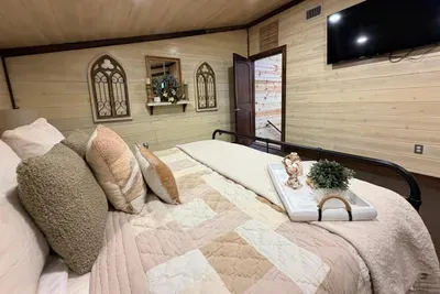 This bedroom feels cozy and personal, with layered textures and a quiet setting perfect for a relaxing stay