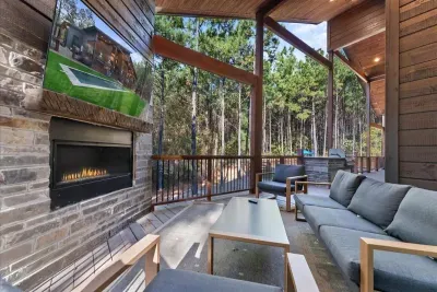Spacious outdoor lounge with a modern fireplace and forest views ideal for relaxing with family and friends