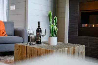 Coffee table with wine, glasses, and cozy seating set around the fireplace